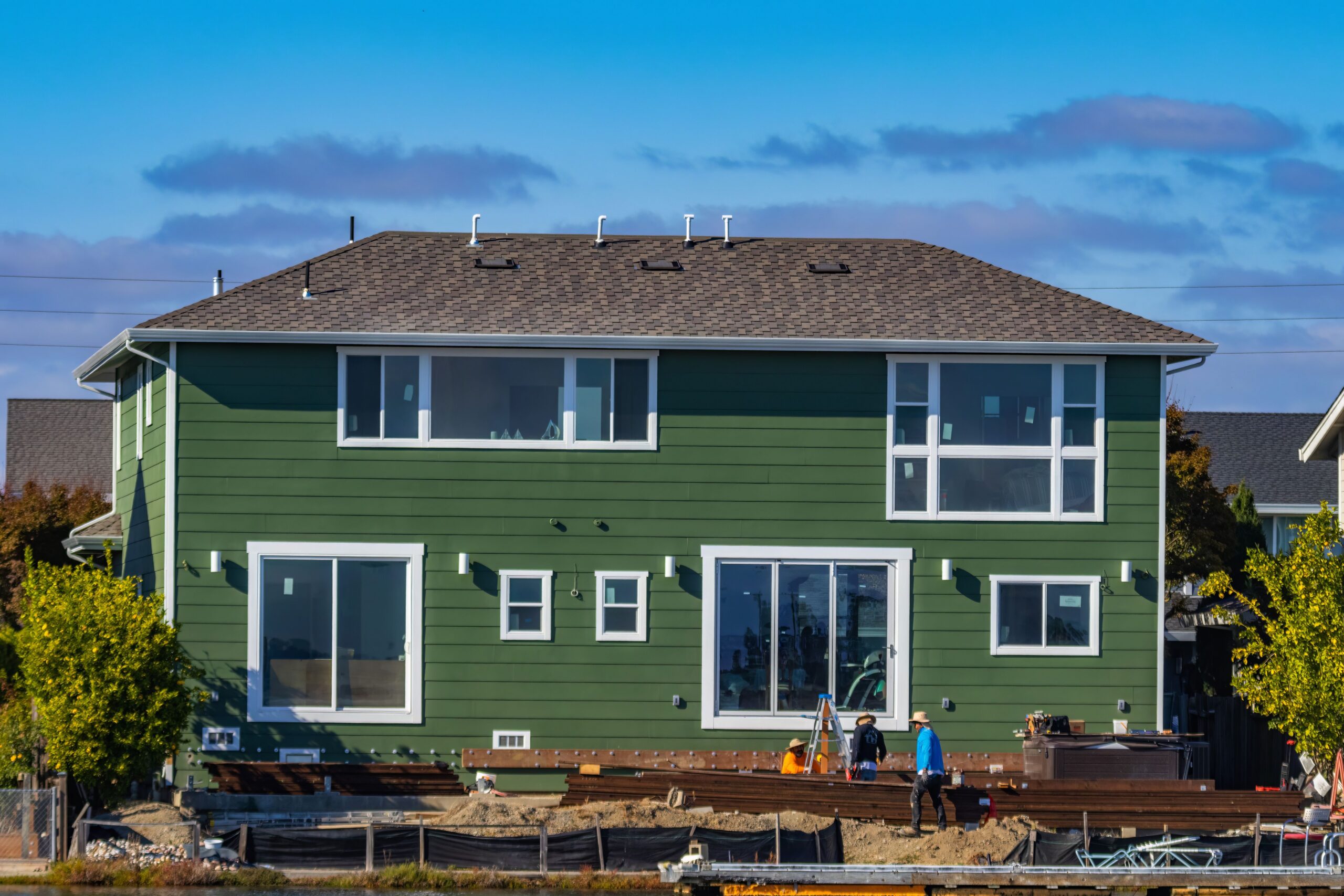 Green lap siding and white-trimmed windows on a Twin Cities home, the kind of siding installation Lakeside Roofing & Remodeling handles.